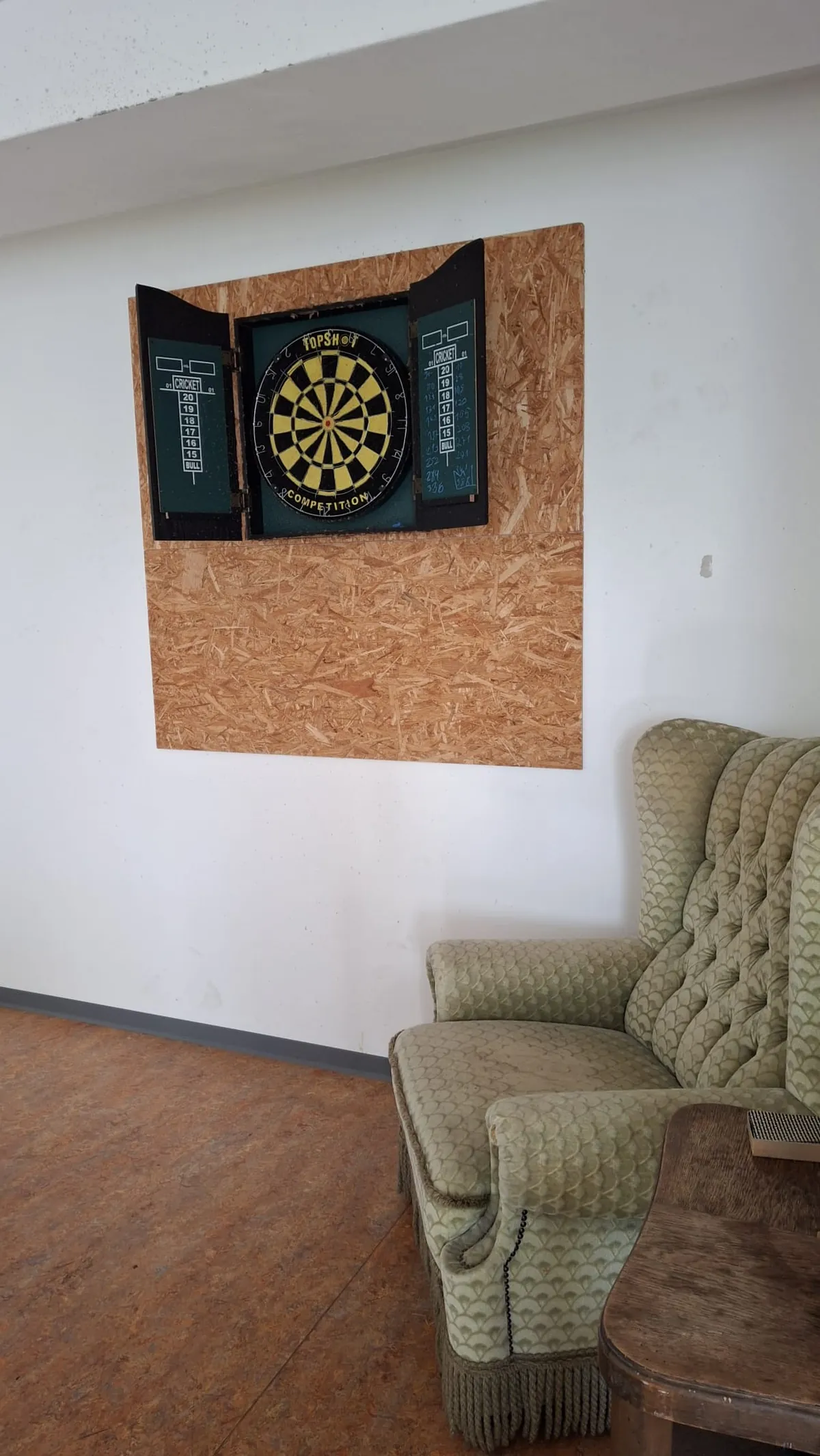 Dartscheibe an der Wand und Ohrensessel
